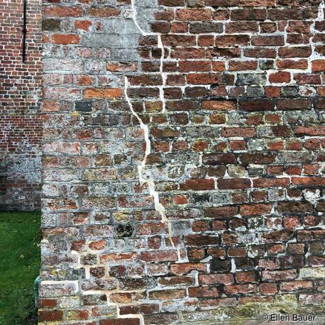 Historisches Mauerwerk aus verschiedenen Jahrhunderten, Kirche Garding. Setzungsrisse wurden mit Muschelkalkmörtel repariert. Muschelkalk ist hochhydraulischer Kalk, als Mörtel feuchteresistent, stabilisierend, elastisch, gut geeignet für solche Problemfälle