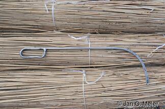 Die gebogene Nadel. Eine Arbeitsersparnis gegenüber dem Nähvorgang bis in die 1980er Jahre. Der „Binnennäher“ (ein Helfer, der innen steht) ist nun nicht mehr nötig. Der gesamte Arbeitsgang des Nähens erfolgt von außen mit einem Reetdachdecker, dem früheren „Butennäher“.